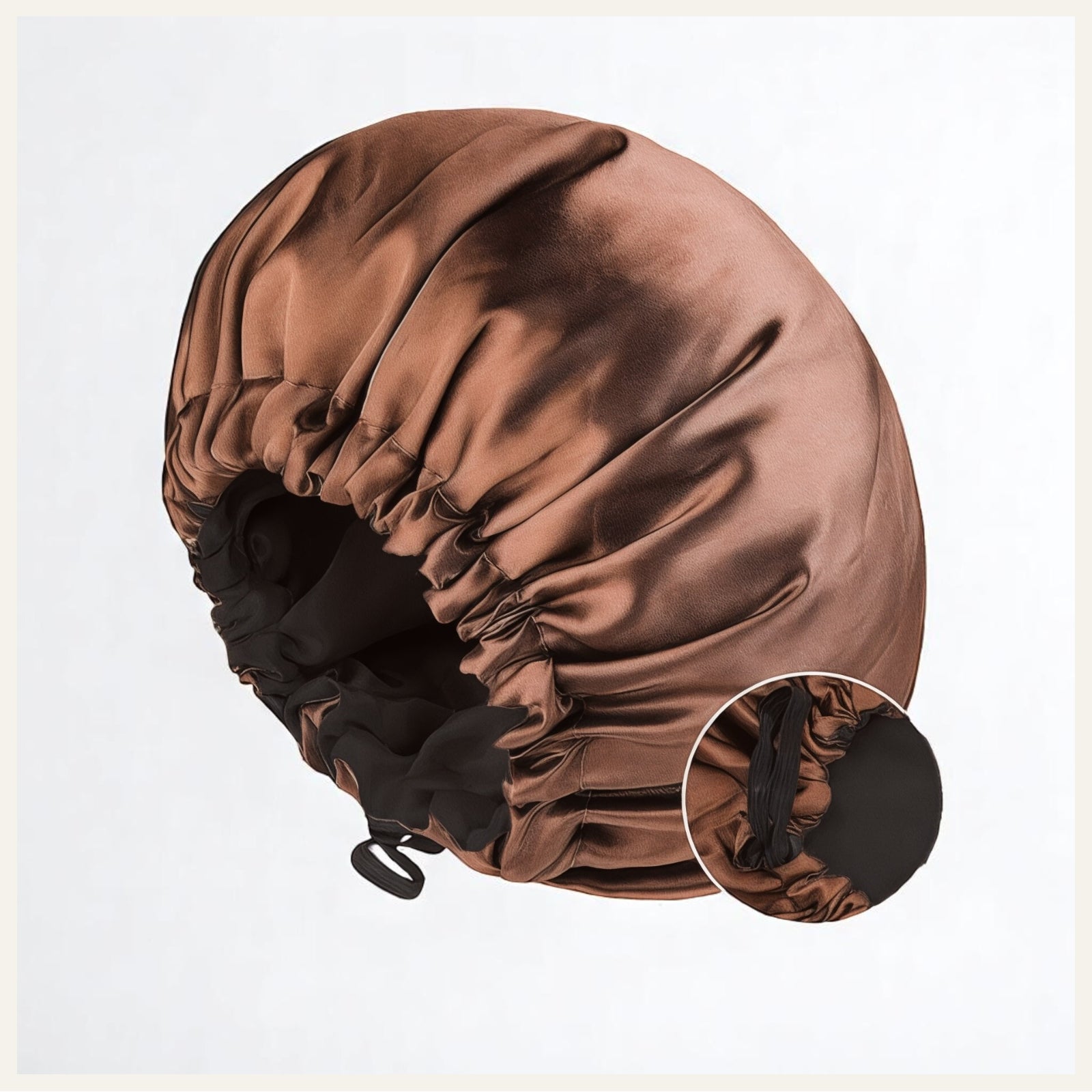 Une charlotte de nuit en satin marron brillant avec intérieur noir, posée sur un fond blanc