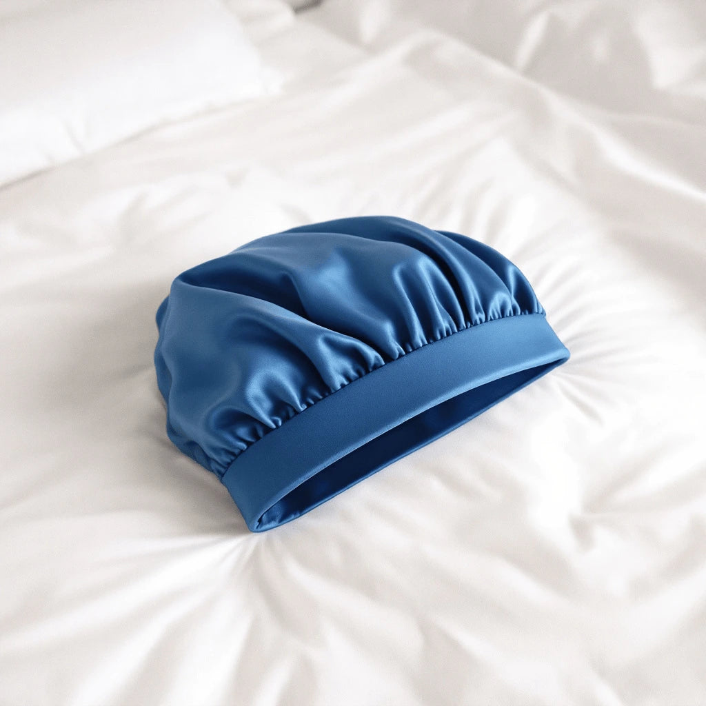 Un bonnet en satin bleu posé sur le lit