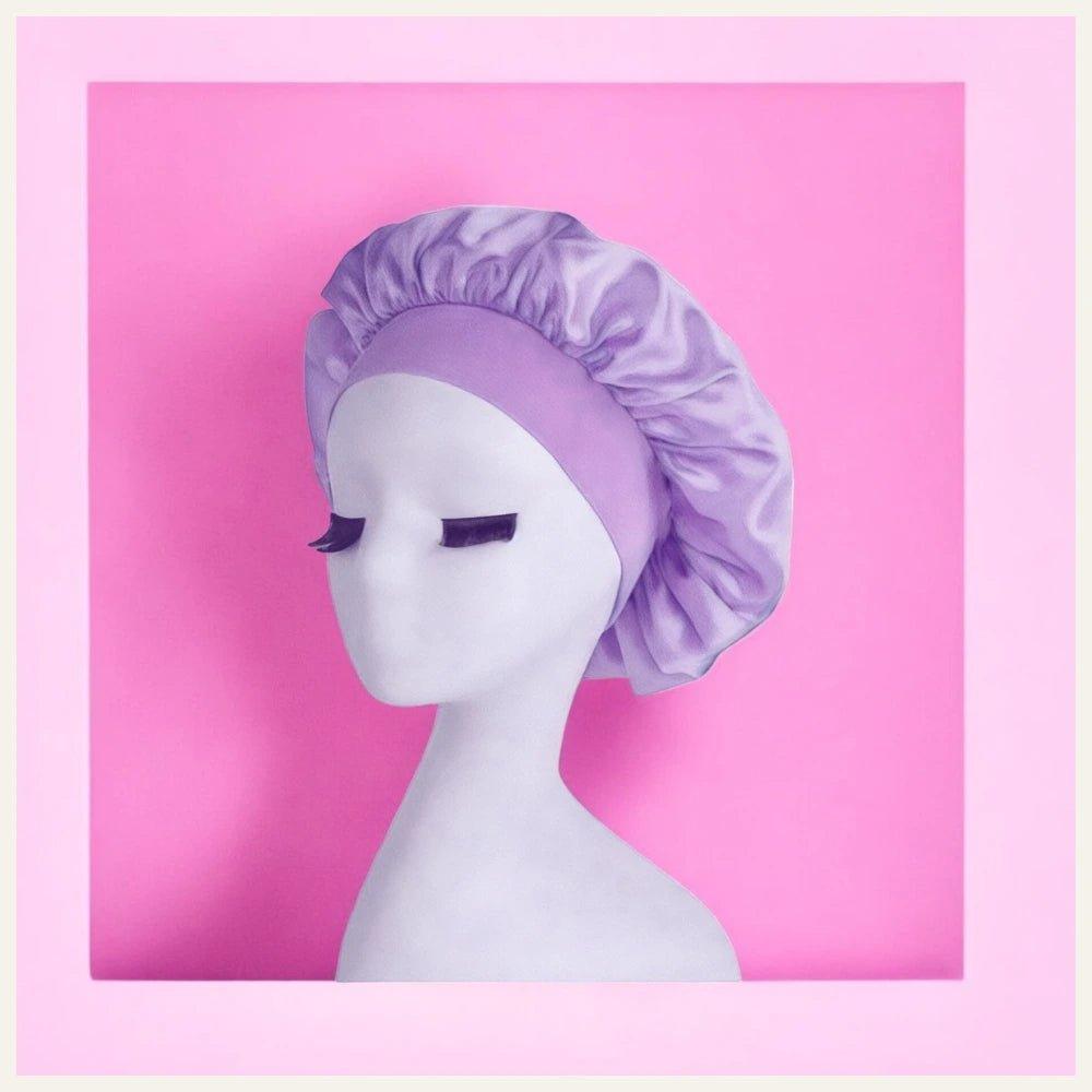 Présentation d'un bonnet en satin violet clair, élégamment disposé sur un fond rose, mettant en valeur son éclat soyeux et son raffinement.