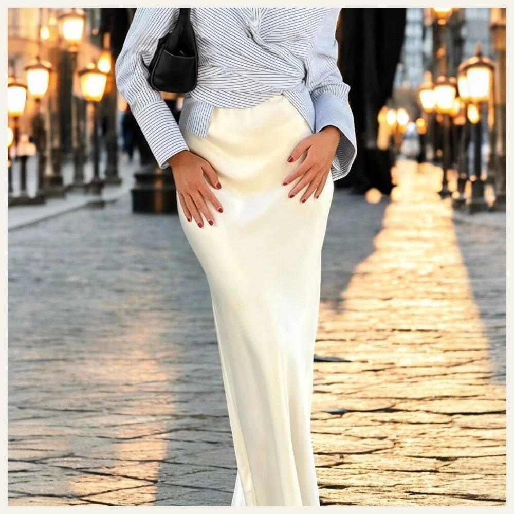 Photographie d'une femme dans la rue, avec seulement la moitié de son corps visible, portant une jupe longue en satin blanc.