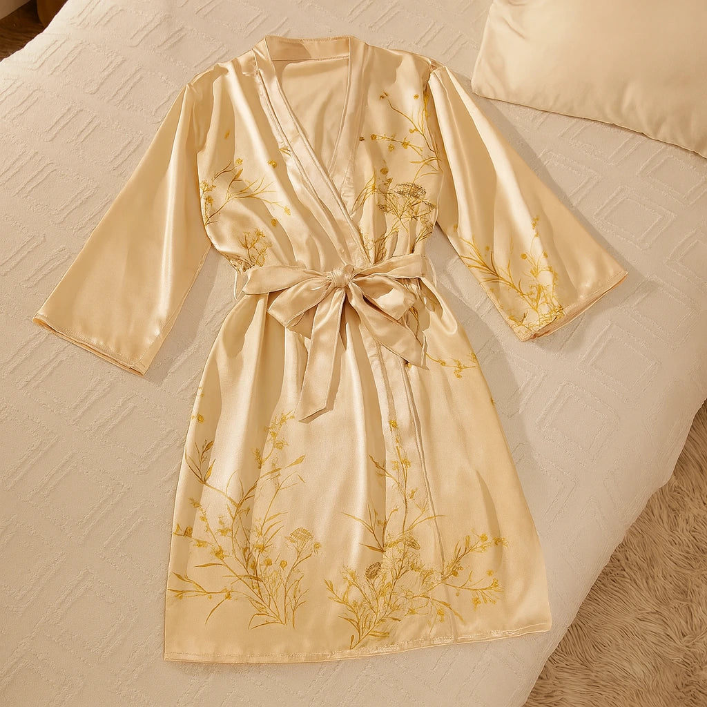 Un kimono en satin beige délicatement posé sur un lit aux tons crème